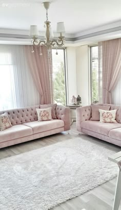 a living room filled with pink couches next to a white rug on top of a hard wood floor