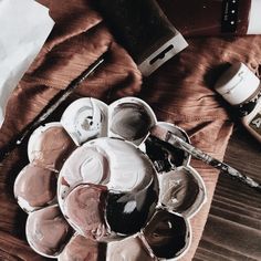 a plate full of paint and brushes on top of a table