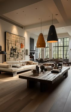 a living room filled with lots of furniture and large windows in the back drop off