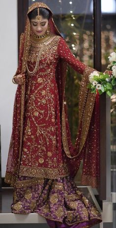 a woman in a red and gold wedding outfit