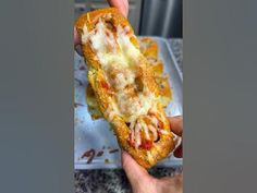 someone holding up a half eaten pizza on a plate with sauce and cheese in it