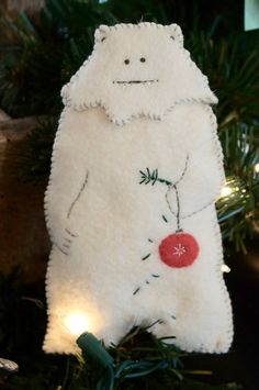 a white bear ornament hanging from a christmas tree