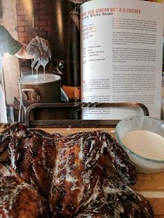 an open cookbook sitting on top of a wooden cutting board