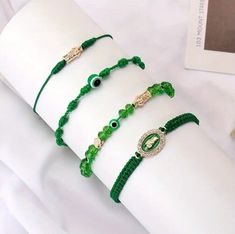 This 4 piece bracelet features traditional charm types from Mexico, including the Evil Eye, Mal de Ojo, San Judas Tadeo, and Pulsera. Each bracelet is handmade with care, and features a unique combination of green beads and a stretch clasp type for a comfortable fit. The round shape of the beads adds to the overall design, creating a stylish and meaningful piece of jewelry. The bracelet is perfect for those who appreciate the theme of luck, and is suitable for both men and women. The charm types are designed to bring good fortune and prosperity, making this a great addition to any jewelry collection. Made with authentic materials and a handmade touch, this bracelet is a must-have for anyone who values traditional Mexican culture. Evita mal de ojo, pulsera curado para proteger del mal de oj Green Ojo Bracelet, Saint Jude, Traditional Mexican, Green Beads, Mexican Culture, Eye Bracelet, Evil Eye Bracelet, Good Fortune, Green Bead