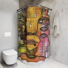 a colorful shower curtain in a bathroom next to a toilet