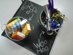 a chalkboard with writing on it next to two buckets filled with candy