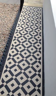 a black and white tiled walkway next to a building