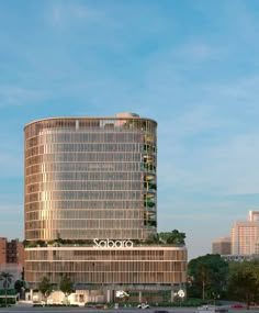 a tall building sitting on the side of a road next to a parking lot with cars parked in front of it