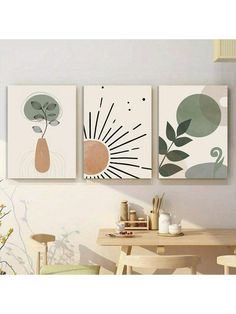 three paintings hanging on the wall above a table