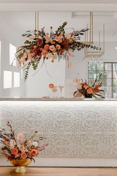 an arrangement of flowers is on display in front of the counter at this wedding reception