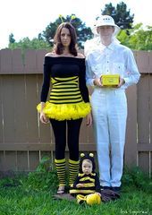 a man and woman in costumes standing next to a baby wearing a bee costume,