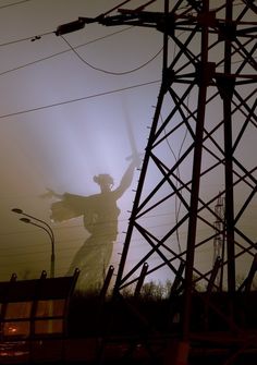 a person standing under power lines with their arms in the air