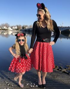 mother and daughter dressed up as minnie mouse for halloween by the water at disney world