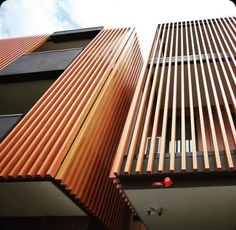 two tall buildings with wooden slats on them