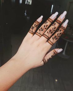 a woman's hand with henna tattoos on it