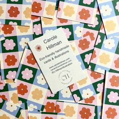 the business card is surrounded by many different colored squares and flowers on pink, green, blue, yellow and white paper