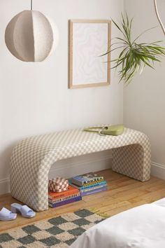 a white bench sitting next to a bed on top of a hard wood floor