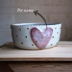 a white bowl with a pink heart painted on it