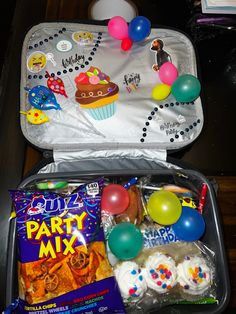 an open suitcase filled with candy and balloons