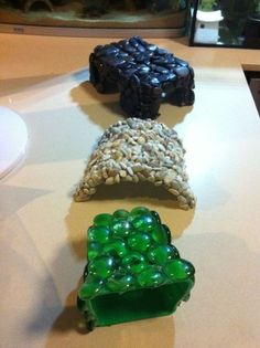 four different colored candy bars sitting on top of a white table next to a fish tank