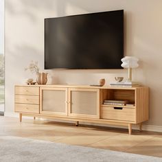 a flat screen tv mounted to the side of a wooden entertainment center in a living room