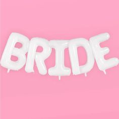 the word bride spelled with white balloons on a pink background