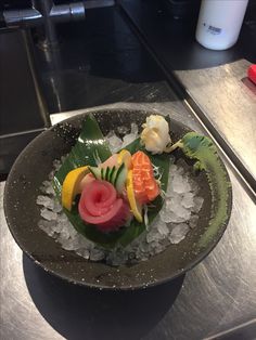 a bowl filled with lots of different types of food on top of ice cubes