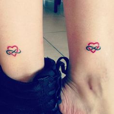 two people with matching tattoos on their legs, one is holding the other's leg