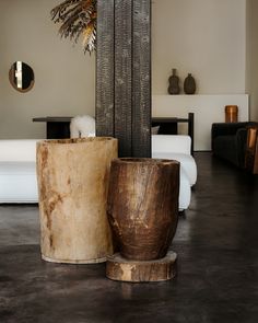 two wooden vases sitting next to each other on the floor in a living room