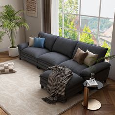 a living room filled with furniture and a large window next to a rug on top of a hard wood floor