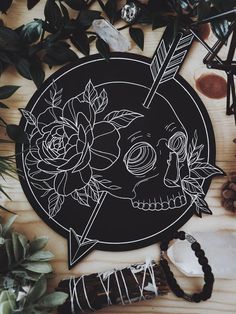 a wooden table topped with lots of plants and flowers next to a skull face cutout