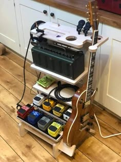 an electric guitar sits on top of a shelf with other electronic devices and gadgets