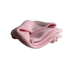 a pink knitted blanket folded on top of it's side, with the end rolled up