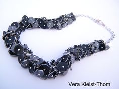 a black and silver necklace on a white background with the words vera kleit - thom written below it