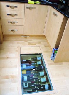 an open floor wine rack in the middle of a kitchen with wooden cabinets and drawers