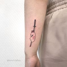 a woman's arm with a tattoo on it that has a hand holding a knife