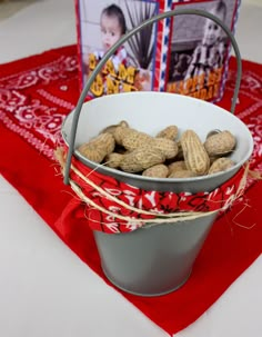 a bucket filled with peanuts sitting on top of a table next to a card and box