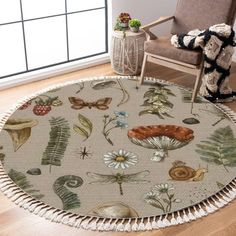 a round rug with flowers and plants on it in a room next to a chair