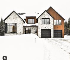 a large house covered in snow with two garages on each side and three windows