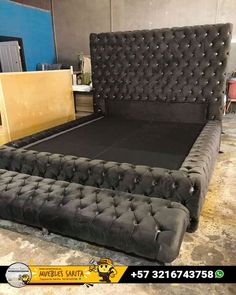 a black bed frame with tufted headboard and foot board in a room filled with furniture