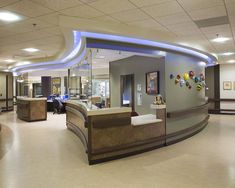 an office lobby with curved reception desks and lights on the ceiling is shown in this image