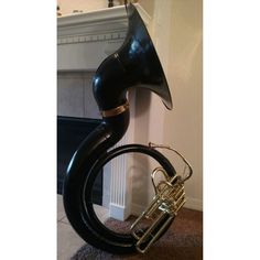 a black and gold instrument sitting on top of a carpeted floor next to a fireplace