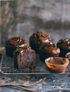 chocolate cupcakes cooling on a wire rack with caramel sauce in the foreground