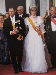 the queen and prince are walking down the red carpet in their official dress for an official state banquet