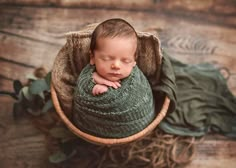 a newborn baby is curled up in a basket