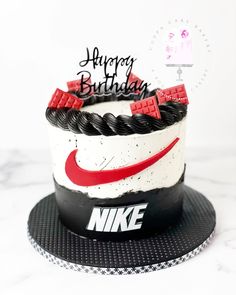 a birthday cake with the nike logo on it and happy birthday written in black, white, and red