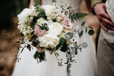 a bride and groom holding their wedding bouquet