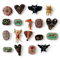 an assortment of pins and brooches on a white background