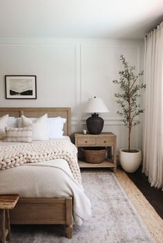 a bedroom with white walls and wooden furniture