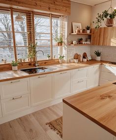 a kitchen filled with lots of wooden counter top next to a stove top oven and sink